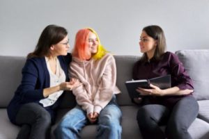 two teen girls talk about entering an intensive outpatient program with a therapist