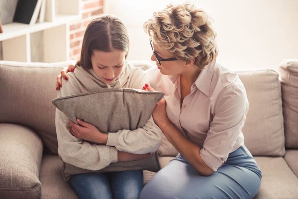 mom comforting her daughter about the signs of emotional abuse