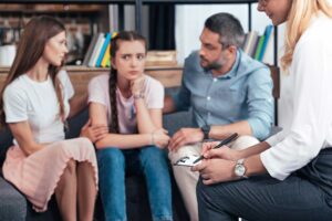 Family in counseling practicing problem solving scenarios for teens