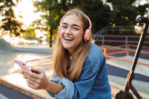 smiling teen listening to music on headphones after finding a music therapy program in Spokane WA